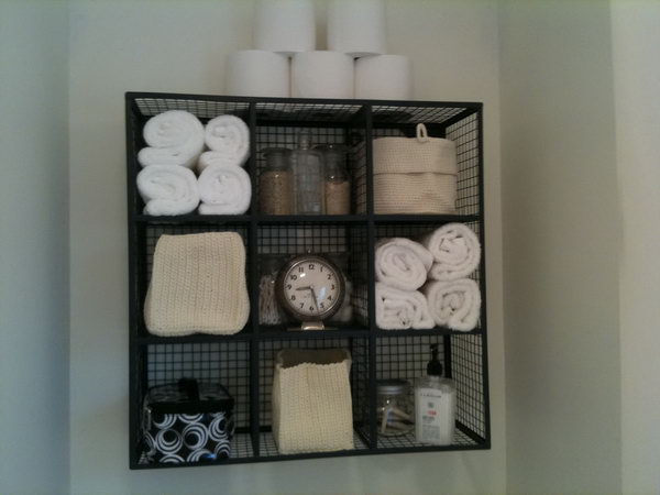 With very limited storage above the toilet , this wire cube storage idea makes functional display. 