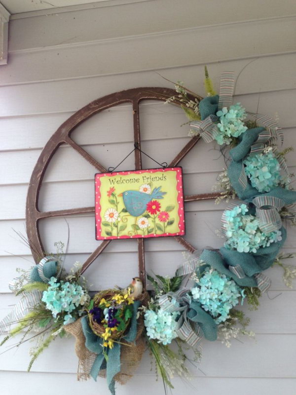 Easter Decorated Wheel Wreath. Wreath becomes a traditional way for Easter decoration with Easter egg, fresh flower, Easter bunny elements. What distinguishes this from other wreath is the floral decorated wheel. There is a picture hang in the centerpiece. 