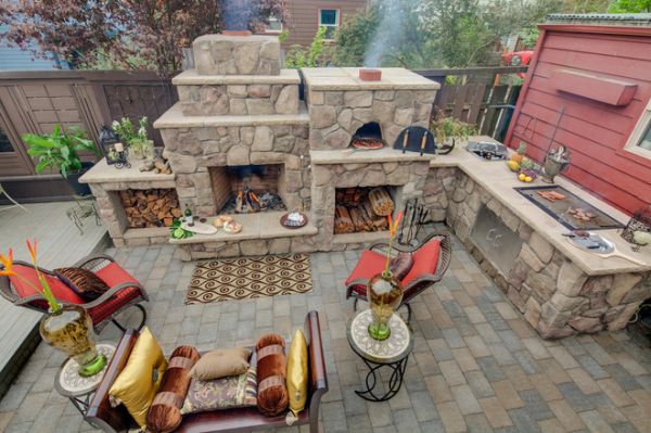 This outdoor kitchen is fully equipped with everything necessary for cooking, a simple pizza oven, fireplace and many other cool cooking tools. 
