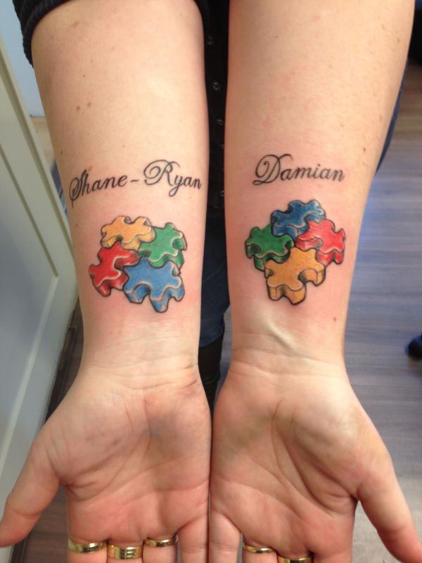 Four different coloured puzzle pieces wrist tattoo