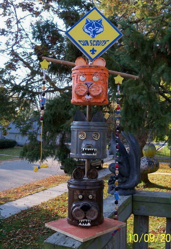 Cub scout totem pole made from recycling plastic coffee cans, apple sauce/dessert cup containers, and buttons for eyes.