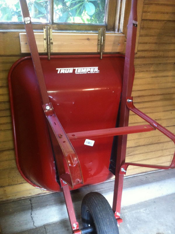 Use sliding locks to keep your wheelbarrow standing up against the wall and out of the way. 