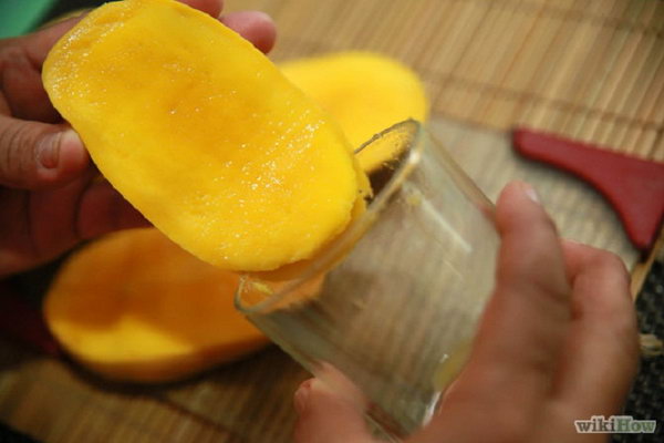 Peel a Mango with a Drinking Glass Edge. The best way to peel a mango. It can be done in just a matter of seconds with no mess.