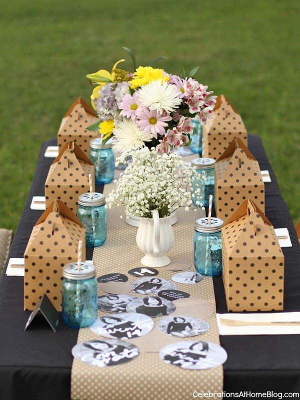 Elegant Graduation Table Decor. Use a chic, black tablecloth filled with flowers, mason jars, gift boxes and painted yearbook with personalized photos of the graduate to create an elegant table decor style to impress every guests come for your great celebration.