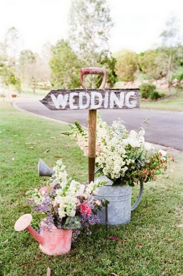 Rustic Wedding Wooden Sign. Finish off your rustic wedding theme with this wooden wedding sign to point the right direction for your guests. Prop it up with pitch for or garden shovel. It’s fantastic to use watering cans as flower holders to add up some decorations.