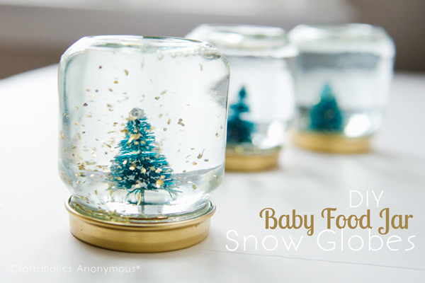 Baby Food Jar Snow Globes. Paint the lids gold, glue trees on the lid. Add gold glittering confetti, fill the jar with distilled water and Glycerin. You'll finish off the stunning mini snow globe for beautiful decor.