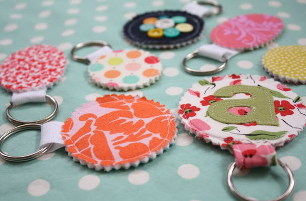 Fabric Scrp Keychains. Cover the pressing cloth with a beautiful applique, sew together and trim the edges, insert into your key chain and sew the opening closed to finish this elegant keychain in a cheap way.