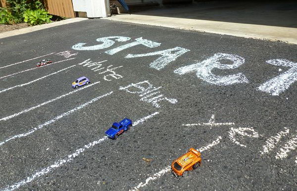 Racetrack on the Driveway. Use tape or chalk to draw lanes down the driveway. You can also make a race ramp out of wrapping paper tubes to give the cars some acceleration. This game is especially designed for boys to play in summer.