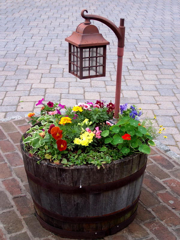 Illuminate Pathways Using Wine Barrel Planter with Lamp Post. 