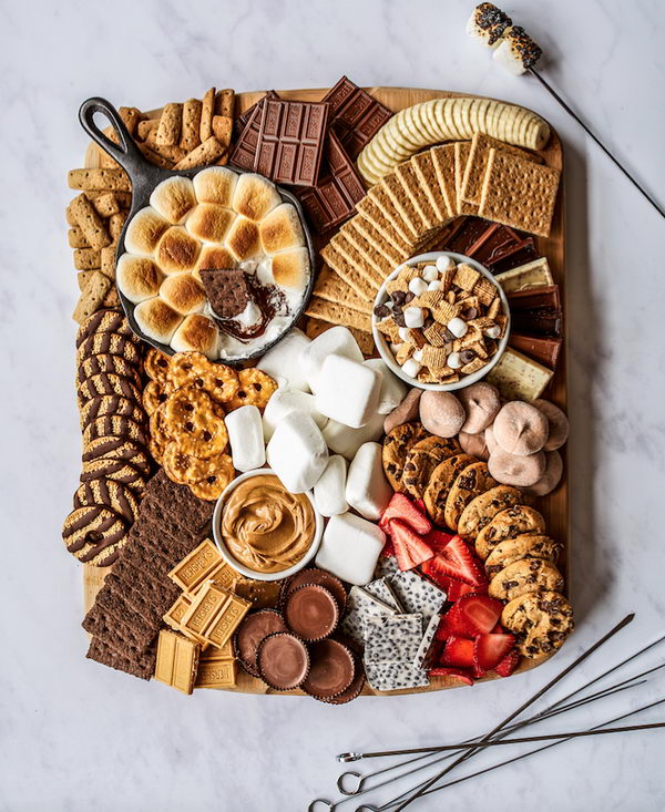 DIY S’mores Board with chocolate, marshmallows, cookies and fruit. 