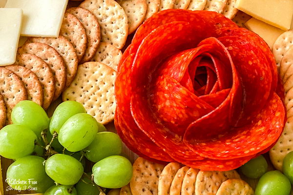 meat and cheese board made with ham and salami flowers. 