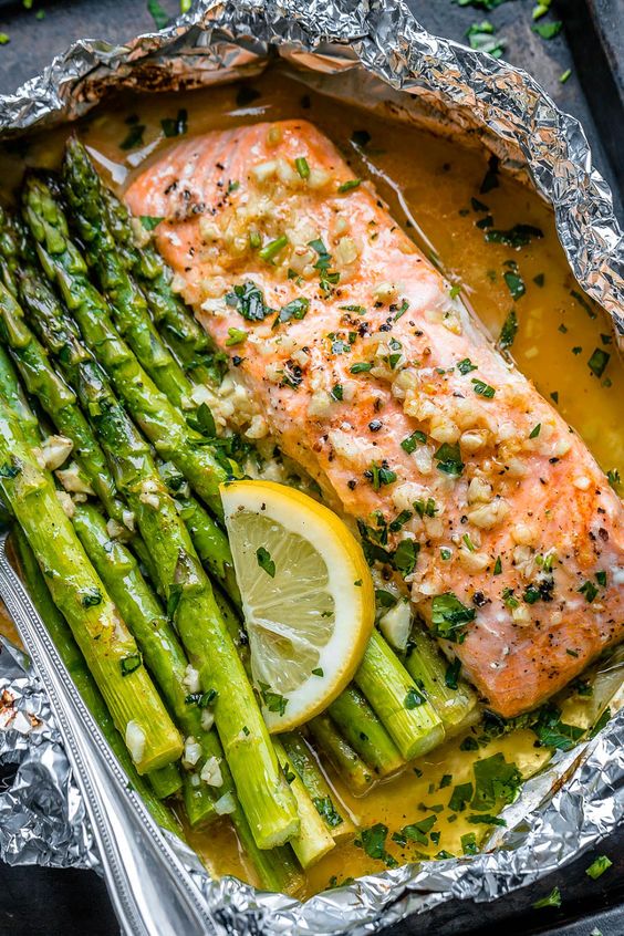 Baked Salmon in Foil Recipe with Asparagus and Garlic Butter Sauce. 