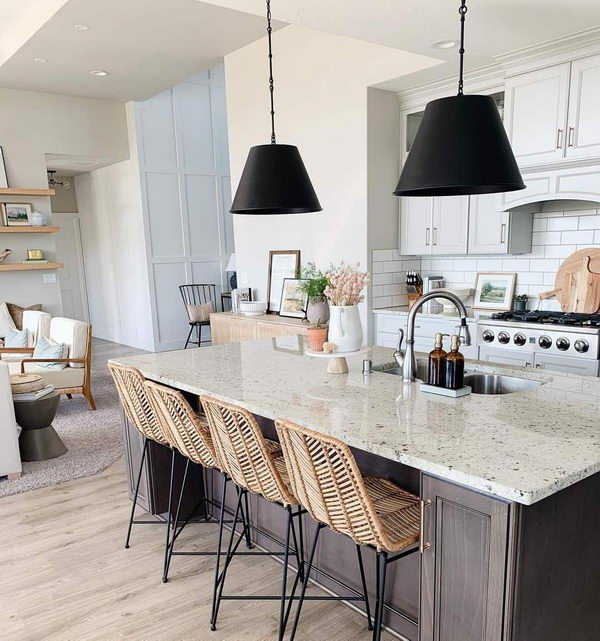 Black Shaded Pendants Over Wicker Island Chairs. 