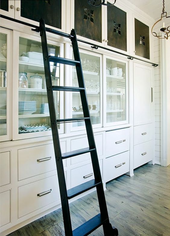 White Kitchen Cabinets With Glass Door And Black Ladder. 